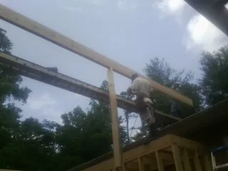 Carpenter setting a ridge beam over a new addition frame — Ice Dam Removal by Roofing Brothers in Emporia