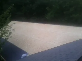 New OSB roof sheathing installed beside an existing shingle roof in Emporia