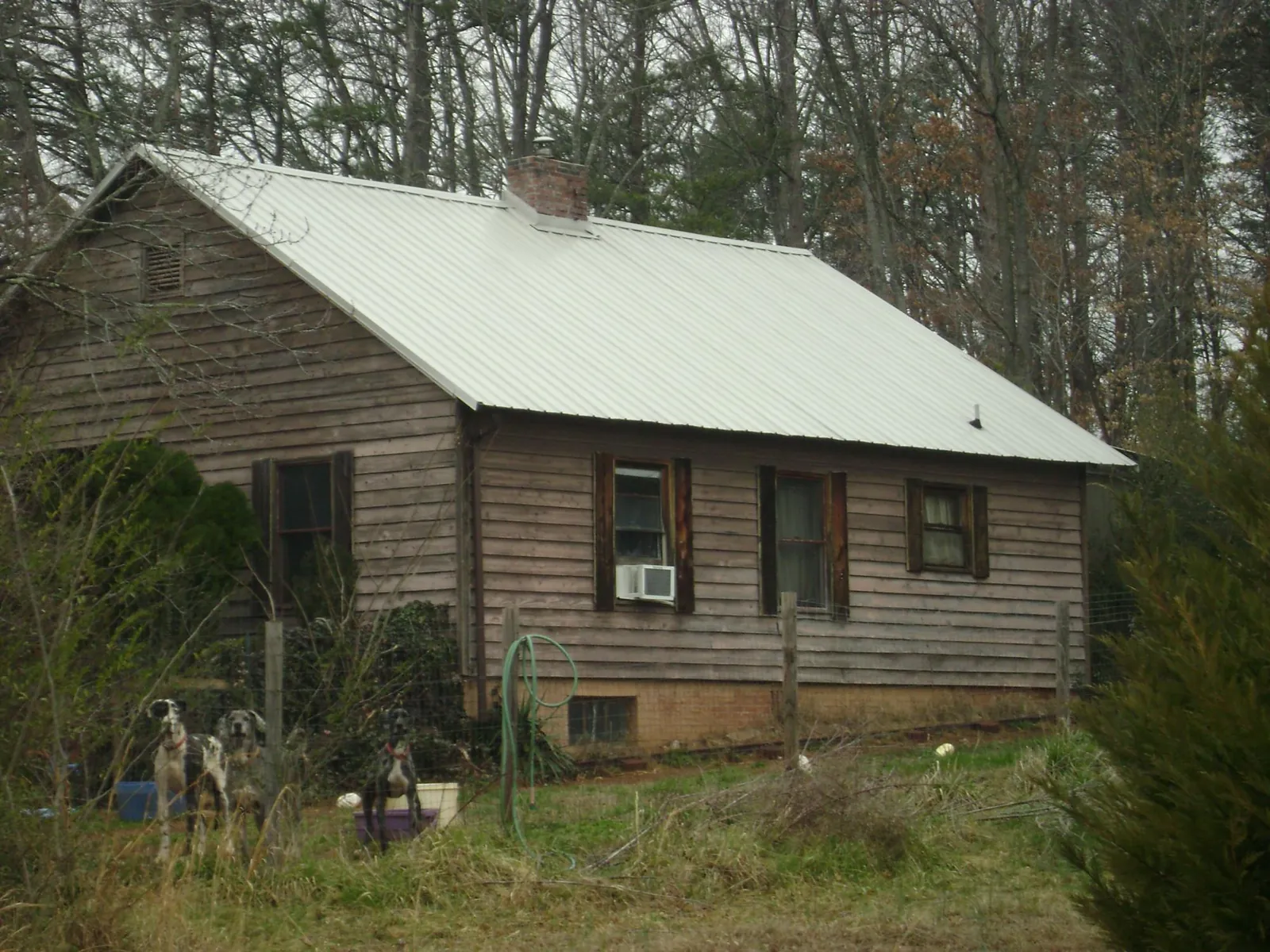 White metal roof on an old wood sided farmhouse, from a Asphalt Shingle Roof Repair job in Emporia